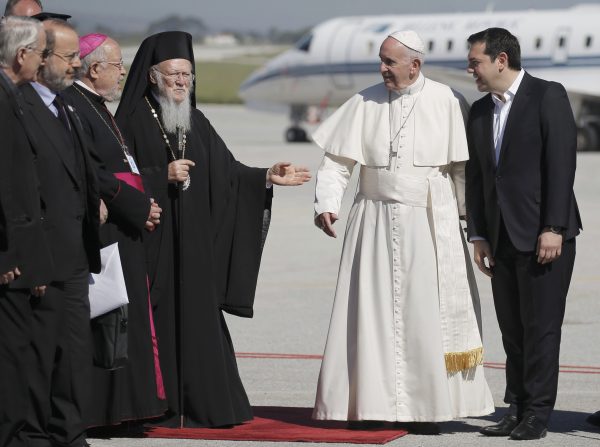 Greek Orthodox Ecumenical Patriarch Bartolomew I (L) and Greek Prime Minister Alexis Trispras (R) welcome Pope Francis as he arrived on the Greek Island of Lesbos for a visit aimed at supporting refugees and drawing attention to the front line of Europe's migration crisis in Lesbos, Greece, April 16, 2016. REUTERS/Alkis Konstantinidis