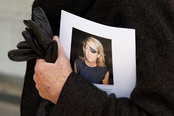 A man holds a sign honoring Sunday Times journalist Marie Colvin after a memorial service, outside St Martin in the Field in London May 16, 2012.    REUTERS/Stefan Wermuth