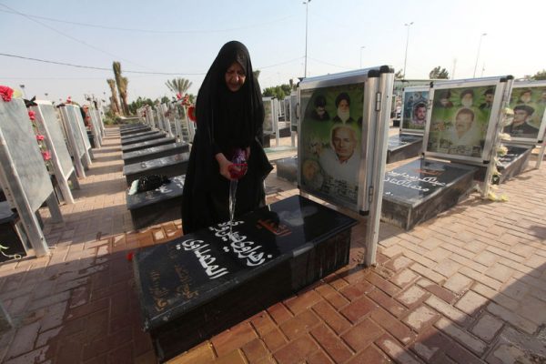 A woman washes the grave of her relative at the Wadi al-Salam cemetery, Arabic for "Peace Valley", in Najaf, south of Baghdad, Iraq August 5, 2016. REUTERS/Alaa Al-Marjani