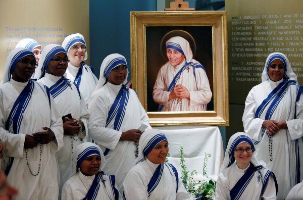 Members of Mother Teresa's order, the Missionaries of Charity, gather around the official canonization portrait of Mother Teresa after the unveiling at the John Paul II National Shrine in Washington, U.S., September 1, 2016. REUTERS/Gary Cameron