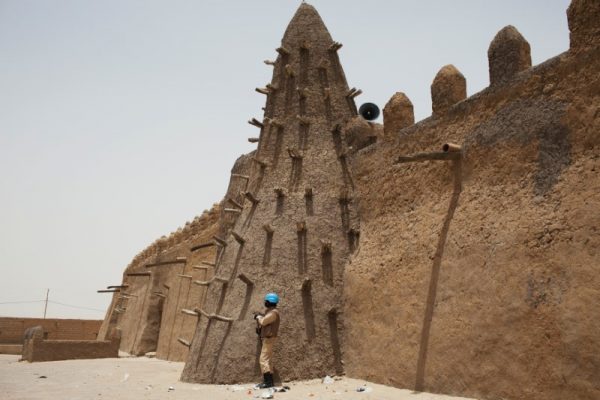 A UN peacekeeper from Burkina Faso stands guard at the Djinguereber mosque, built in the 14th century, during a visit by a UN delegation on election day in Timbuktu, Mali, July 28, 2013.  REUTERS/Joe Penney/Files