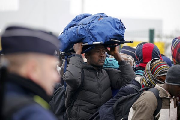 French police stand near as migrants with their belongings queue near barriers at the start of their evacuation and transfer to reception centers in France, and the dismantlement of the camp called the "Jungle" in Calais, France, October 24, 2016.   REUTERS/Pascal Rossignol